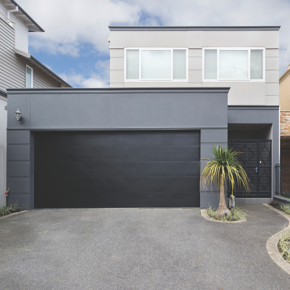 Premium black textured sectional door on a contemporary facade